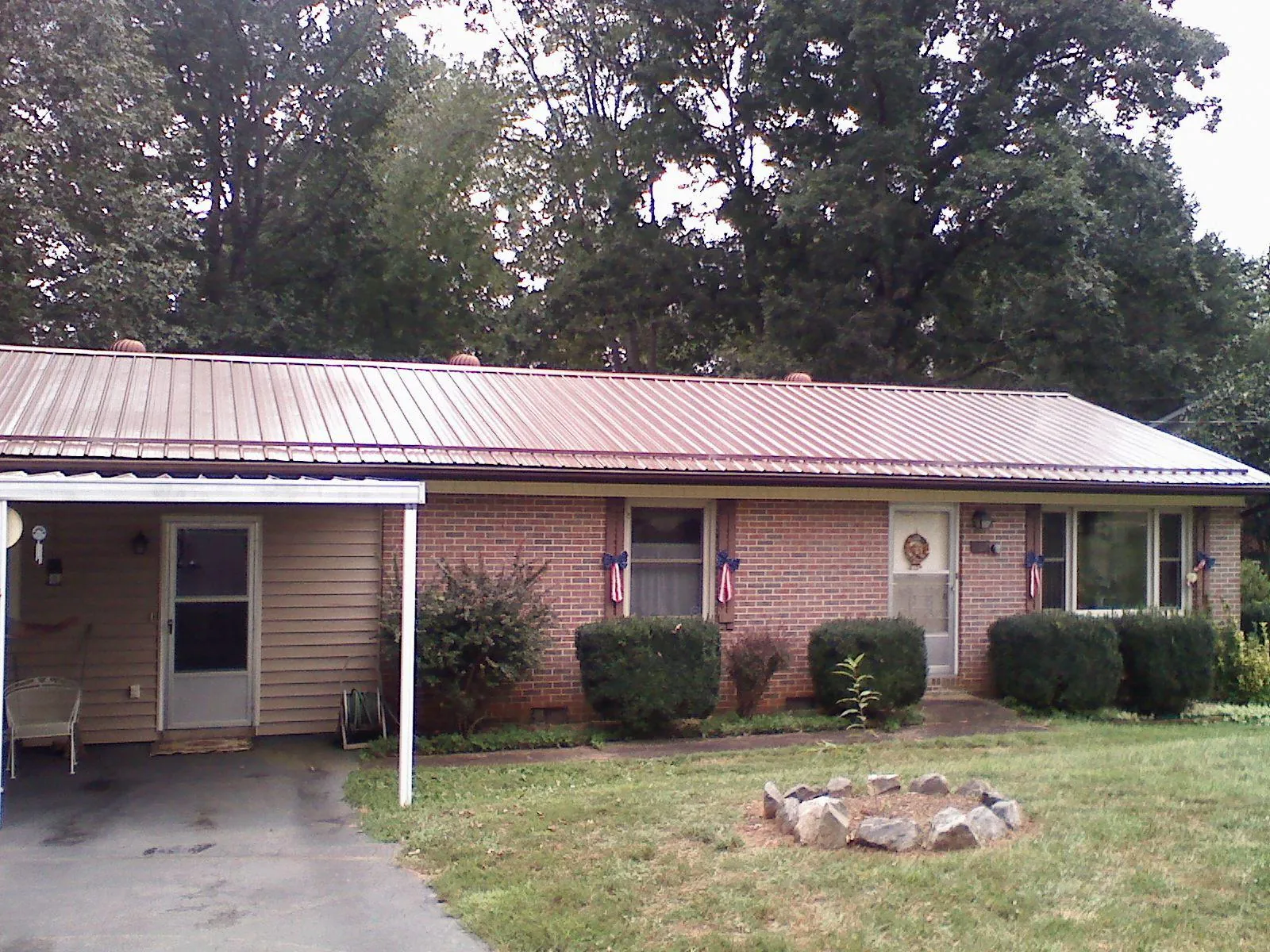Bronze metal roof and carport on a brick ranch home — Roof Repair work by our crew in Poteet