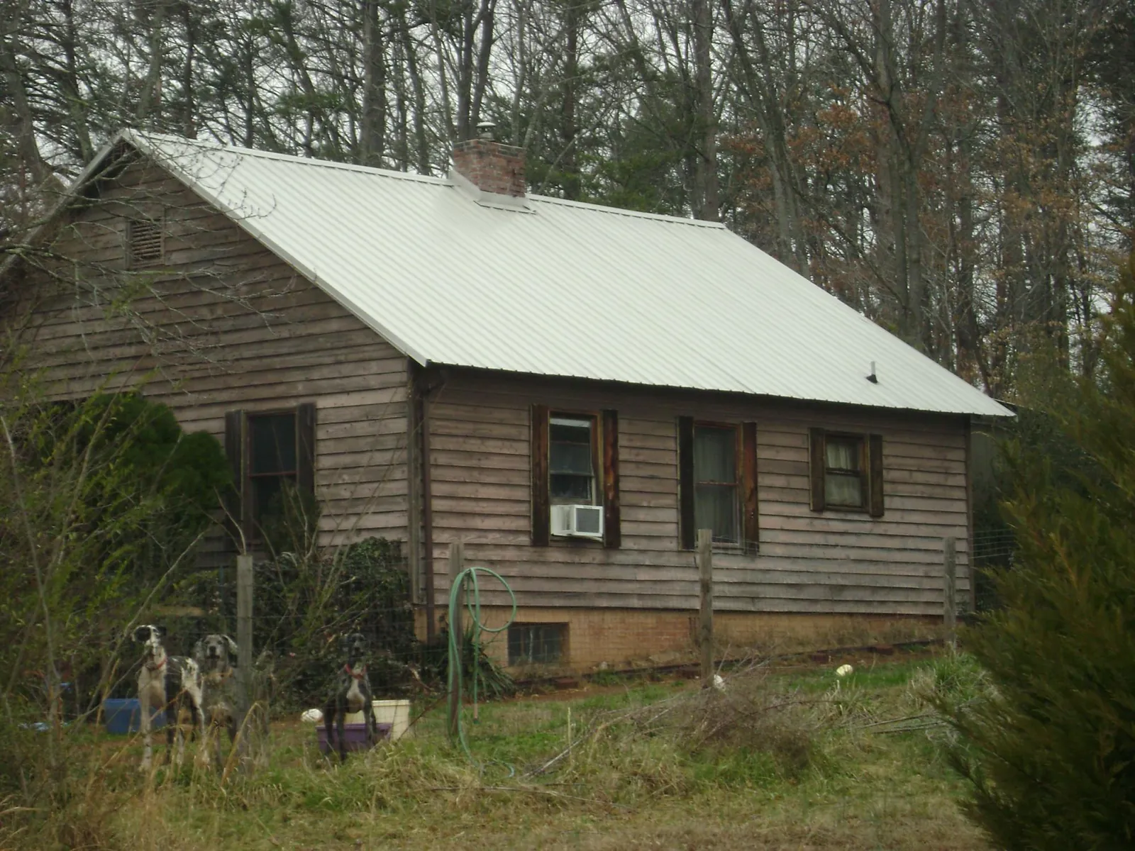 White metal roof on an old wood sided farmhouse, from a Metal Roof Installation job in Poteet